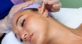 a woman having a candling session to her ear