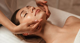 a woman receiving a facial beauty massage