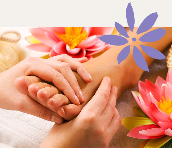 a person receiving a foot massage next to water lily flowers